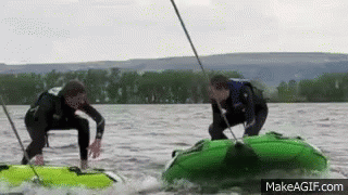 Two Men Are Riding Tubes On A Lake With Makeagif.com At The Bottom Of The Screen GIF