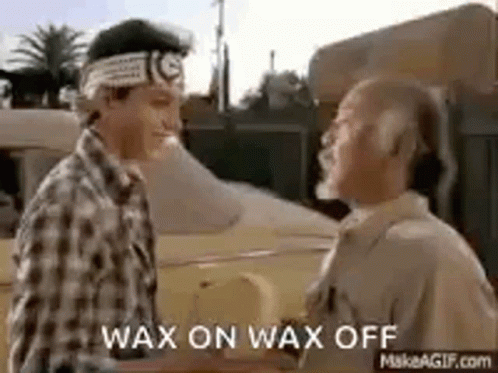 Two Men Are Shaking Hands In Front Of A Car And They Are Talking To Each Other . GIF