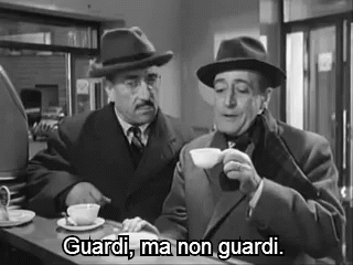 Two Men Are Sitting At A Counter Drinking Coffee And One Of Them Is Saying `` Guardi , Ma Non Guardi '' . GIF
