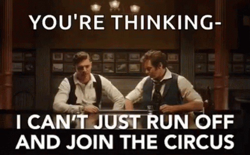 Two Men Are Sitting At A Table Drinking Whiskey And Talking To Each Other In A Bar . GIF