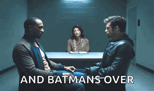 Two Men Are Sitting At A Table With A Woman Behind Them And The Words " And Batmans Over " Are Visible GIF