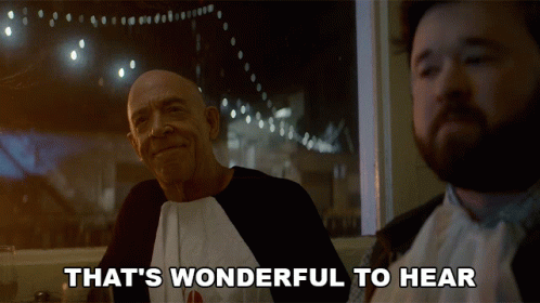 Two Men Are Sitting At A Table With The Words That 'S Wonderful To Hear GIF
