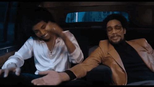 Two Men Are Sitting In A Car And One Is Wearing Glasses GIF
