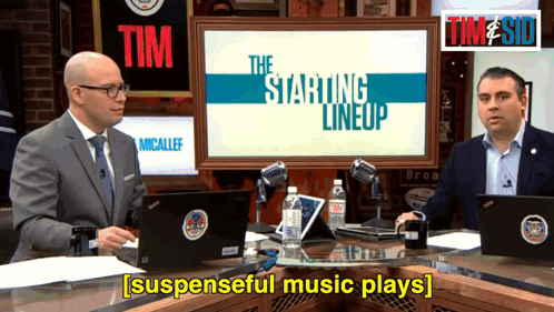 Two Men Are Sitting In Front Of A Screen That Says The Starting Lineup On It GIF