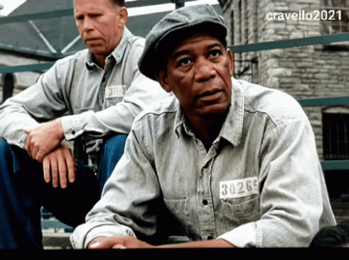 Two Men Are Sitting Next To Each Other And One Has A Tag On His Shirt That Reads 30269 GIF
