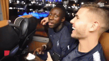 Two Men Are Sitting Next To Each Other And One Of Them Is Giving A Thumbs Up Sign GIF