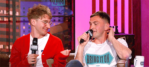 Two Men Are Sitting Next To Each Other And One Of Them Is Wearing A Shirt That Says Burlington GIF