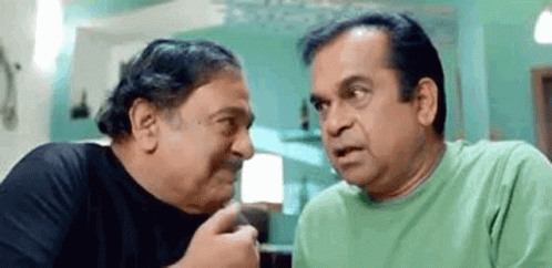 Two Men Are Sitting Next To Each Other And Talking To Each Other . One Of The Men Is Wearing A Green Shirt . GIF