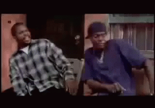 Two Men Are Sitting Next To Each Other In A Room And Smiling . One Of The Men Is Wearing A Purple Shirt . GIF