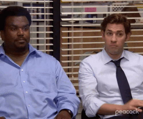 Two Men Are Sitting Next To Each Other In Front Of A Window In An Office . GIF