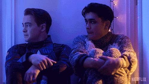 Two Men Are Sitting Next To Each Other With A Netflix Logo In The Background GIF