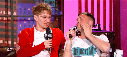 Two Men Are Sitting On A Couch And One Of Them Has A Shirt That Says Brington GIF