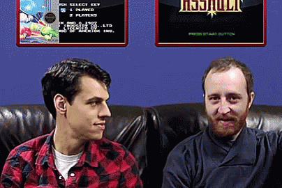 Two Men Are Sitting On A Couch In Front Of A Screen That Says ' Resjuult ' On It GIF