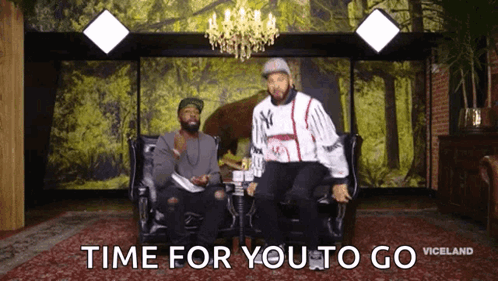 two men are sitting on a couch with the words time for you to go
