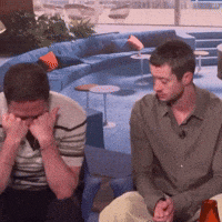 Two Men Are Sitting On A Couch With Their Eyes Closed GIF