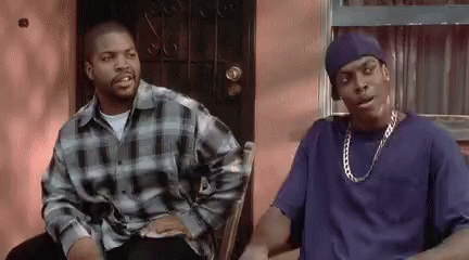 Two Men Are Sitting On A Porch Talking To Each Other . One Of The Men Is Wearing A Blue Shirt . GIF