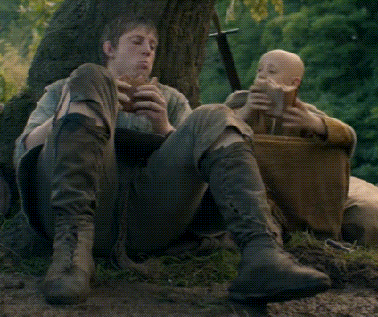 Two Men Are Sitting Under A Tree Eating Bread And Drinking Beer GIF