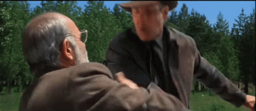 Two Men Are Standing In A Field And One Has A Beard GIF