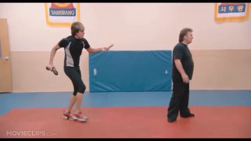 Two Men Are Standing In A Gym With A Sign That Says Samurang On It GIF