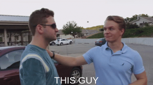 Two Men Are Standing In A Parking Lot And The Word This Guy Is On The Bottom Right GIF