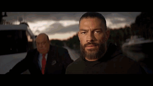 Two Men Are Standing In A Wrestling Ring And One Has A Shirt That Says Tribal Chief On It GIF