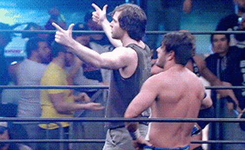 Two Men Are Standing In A Wrestling Ring And One Is Pointing GIF