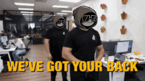 Two Men Are Standing In An Office With The Words We 'Ve Got Your Back On The Bottom GIF