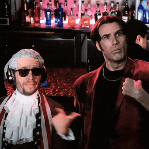 Two Men Are Standing In Front Of A Bar With Bottles Of Liquor GIF