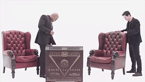 two men are standing in front of a box that says radiola television