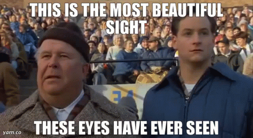 Two Men Are Standing In Front Of A Crowd Of People And Looking Up At The Sky . GIF