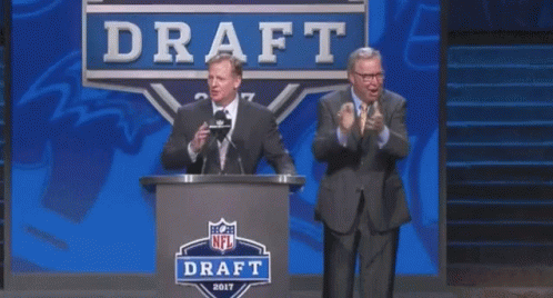 Two Men Are Standing In Front Of A Podium That Says Draft GIF
