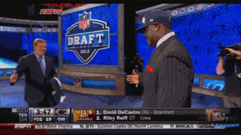 Two Men Are Standing In Front Of A Sign That Says Draft GIF