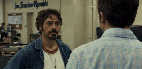 Two Men Are Standing In Front Of A Sign That Says San Francisco Opsmide GIF
