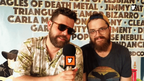 Two Men Standing In Front Of Triangle Sign GIF