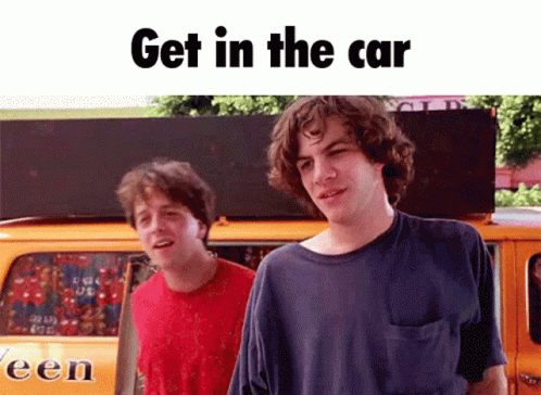 Two Men Are Standing In Front Of A Van That Says Een On It GIF