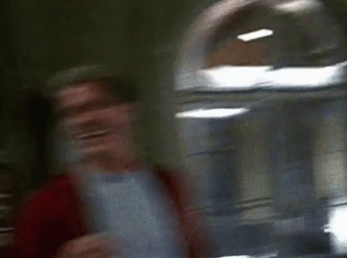 Two Men Are Standing Next To Each Other And Laughing In A Room . GIF