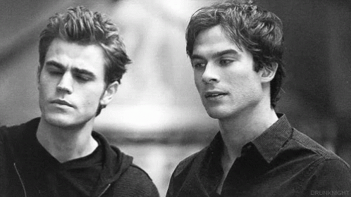 Two Men Are Standing Next To Each Other And Looking At Each Other . GIF