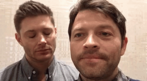 Two Men Are Standing Next To Each Other And Making Funny Faces With Their Eyes Closed . GIF