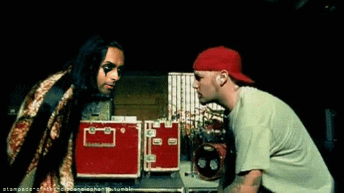 Two Men Are Standing Next To Each Other And One Has A Red Hat GIF