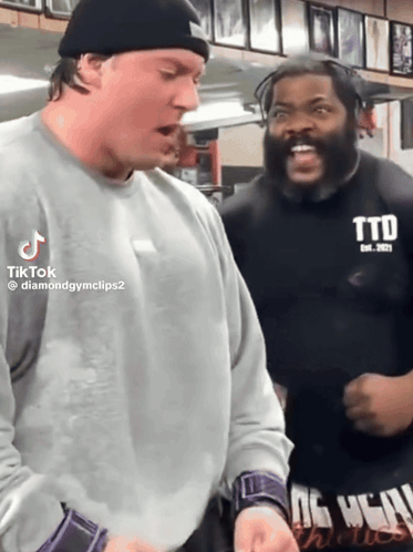 Two Men Are Standing Next To Each Other And One Has A Shirt That Says Ttd GIF