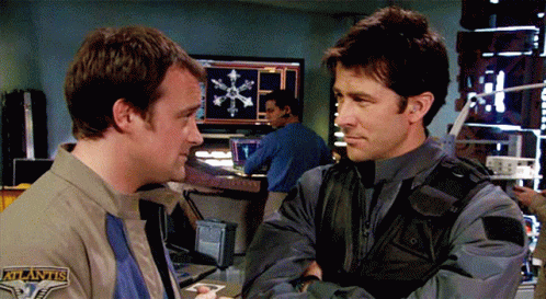 Two Men Standing One With Atlantis Patch GIF