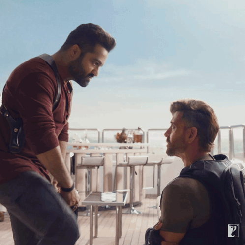 Two Men Are Standing Next To Each Other And One Has The Letter Z On His Backpack GIF