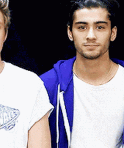 Two Men Are Standing Next To Each Other And One Of Them Is Wearing A Blue Hoodie GIF