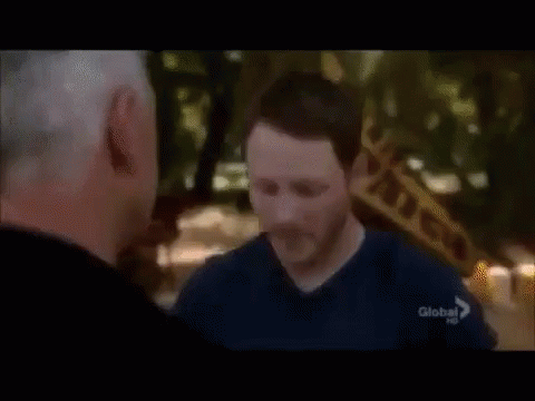 Two Men Are Standing Next To Each Other And One Of Them Is Wearing A Blue Shirt With The Word Global On It . GIF