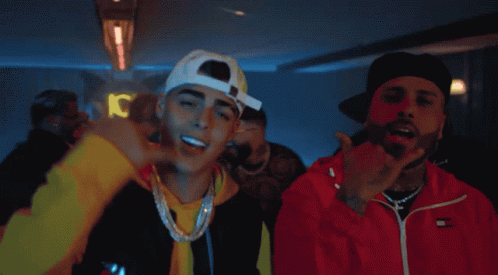 Two Men Are Standing Next To Each Other And One Of Them Is Wearing A Red Tommy Hilfiger Jacket GIF