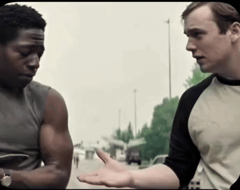 Two Men Are Standing Next To Each Other And One Of Them Is Wearing A Shirt With The Letter H On It GIF