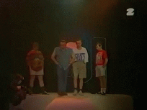 Two Men Are Standing Next To Each Other And One Of Them Is Wearing A White Shirt With The Letter Z On It . GIF