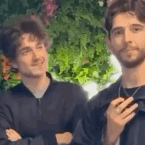 Two Men Are Standing Next To Each Other And Smiling . GIF