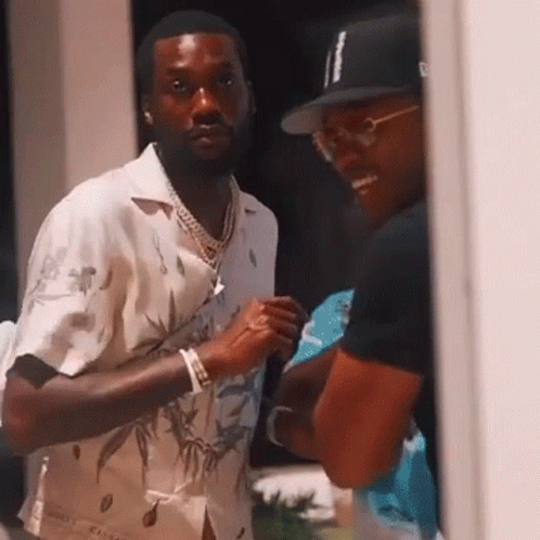 Two Men Are Standing Next To Each Other And Talking . One Of The Men Is Wearing A Hat . GIF