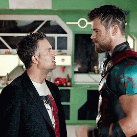 Two Men Are Standing Next To Each Other And Talking To Each Other In A Kitchen . GIF